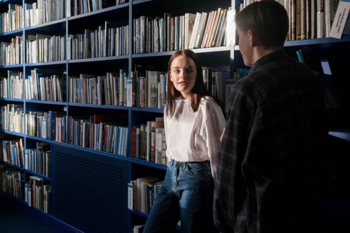 man and woman casually talking inside the library