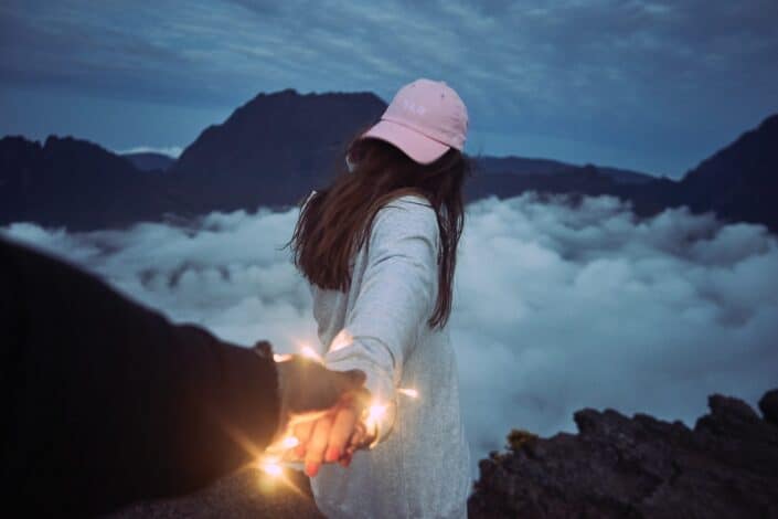 Woman's hand held by an illuminating hand