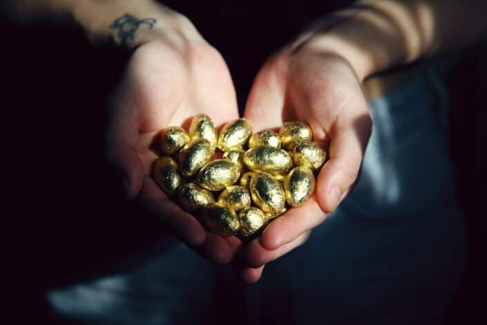 golden pebbles held by two hands