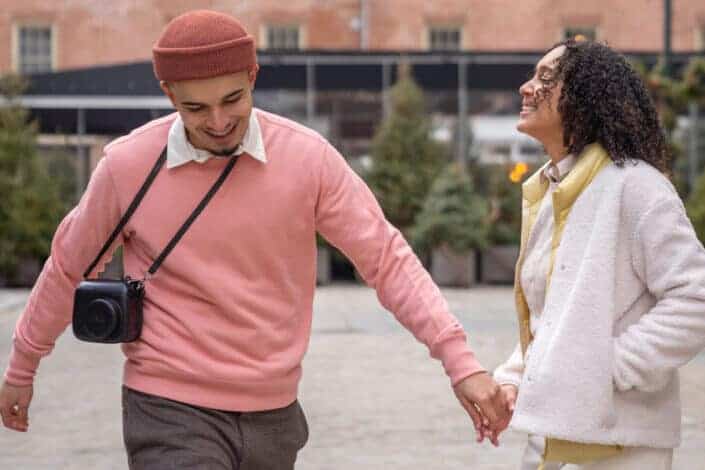 couple smiling and holding hands on urban street