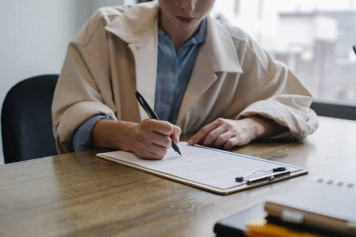 woman writing in clipboard 