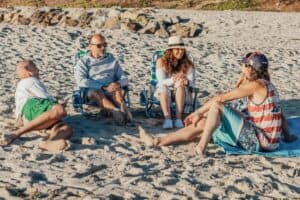 A group of people having a good conversation on the sand by the sunset. - who knows me better questions