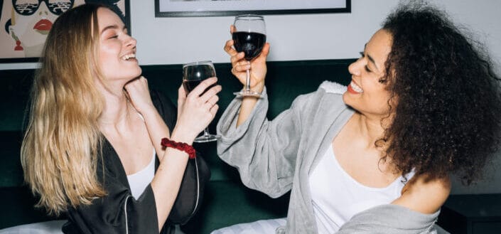 women enjoying their red wine inside a room