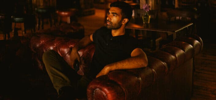 man in black shirt sitting on sofa