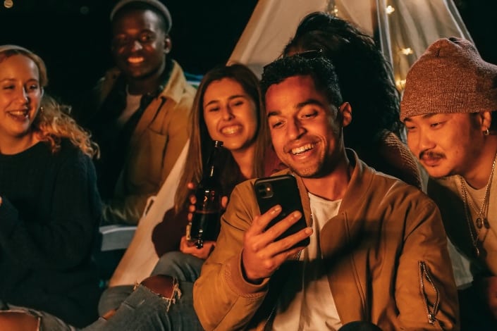 man showing his mobile phone to his friends