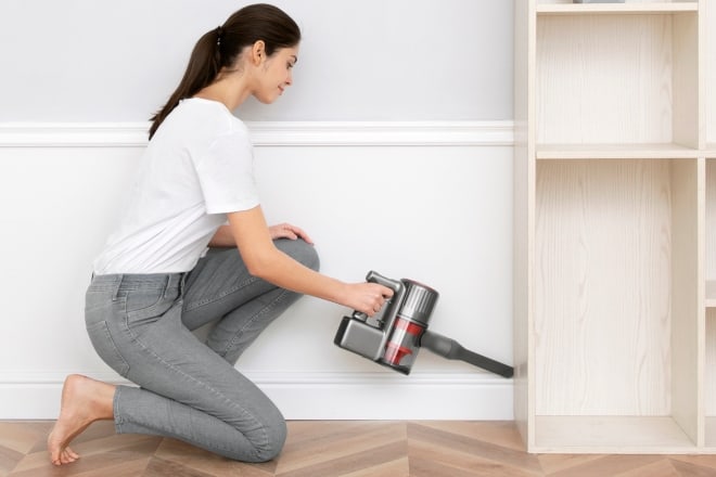 woman cleaning the side of cabinet - Roborock H7 Cordless Stick Vacuum Review