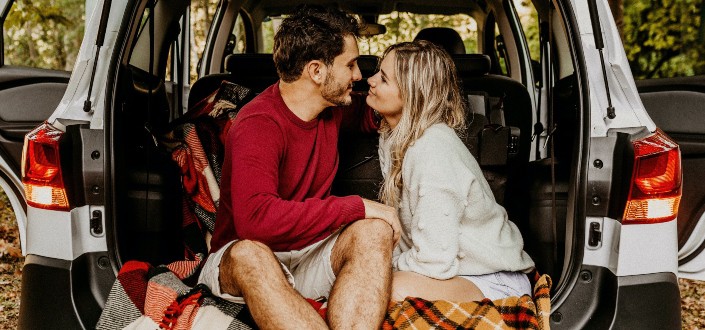 Sweet couple having intimate moment at the car's rear compartment.