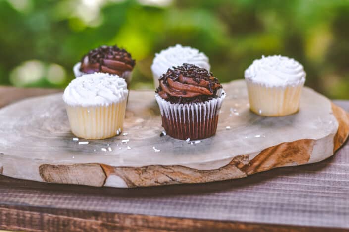 five cupcakes on wooden board