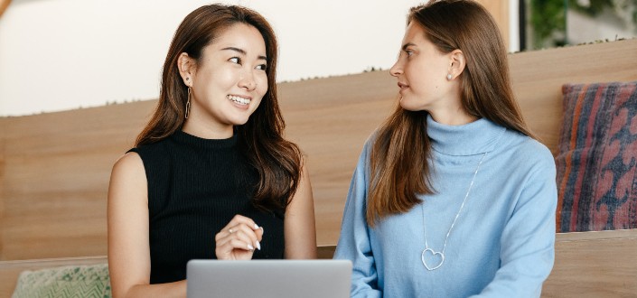 content cheerful diverse women talking and using laptop