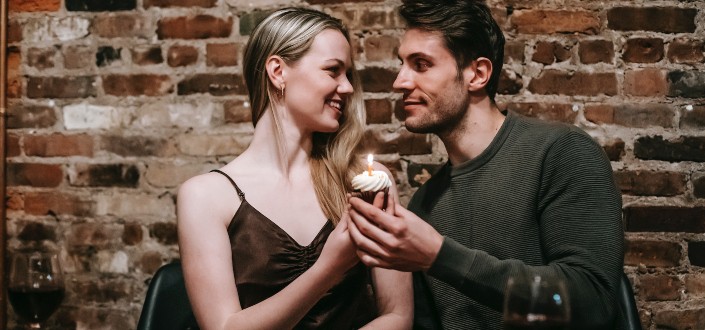 couple with cupcake celebrating in restaurant