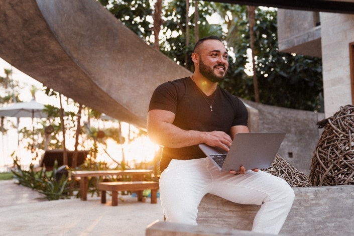 hunk man sitting while holding the laptop