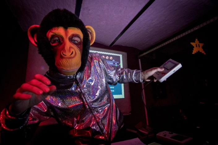 man dress as monkey and holding game boy