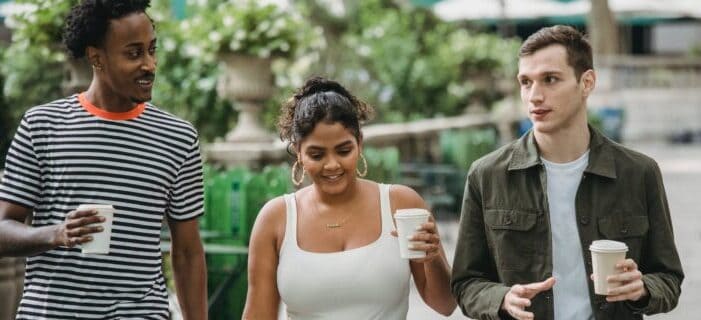 Three friend talking over with coffee in their hands