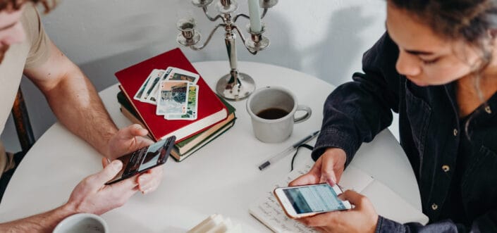 Man and woman texting while having coffee.