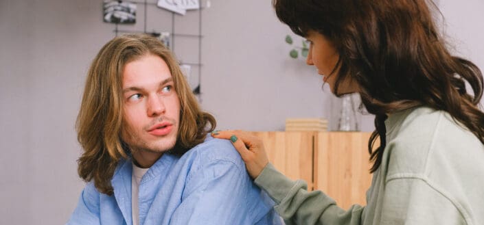 Woman patting a man shoulder