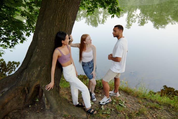 Two women friends chilling with a guy beneath a lake.