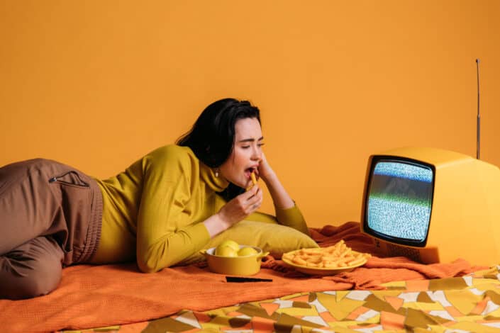Woman in Yellow Long Sleeve Shirt Watching TV