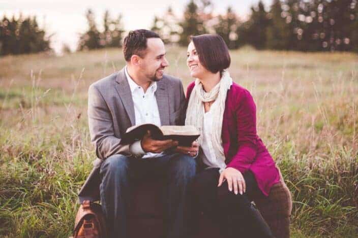 Couple reading book outside