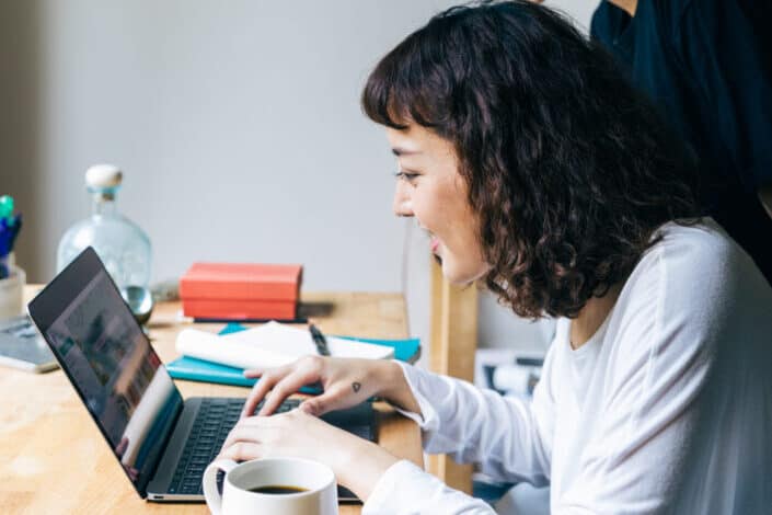 Friends cheerfully using laptop in room