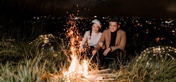 Couple sitting near bonfire