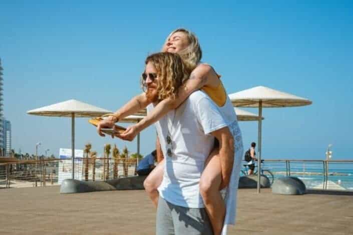 Man carrying his woman by the beach