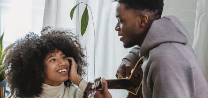 Man Playing a Guitar to His Girl