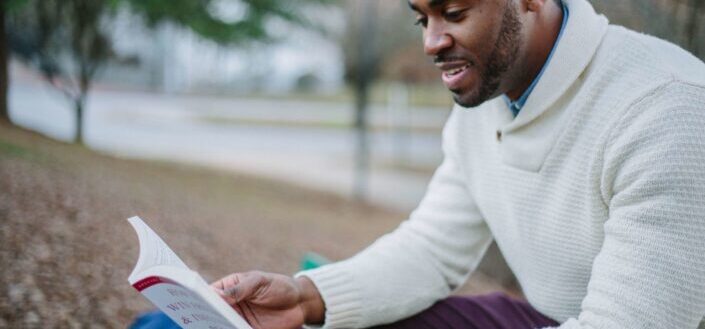 Man reading a book in a park