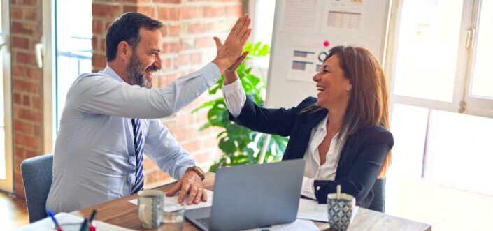 Coworkers delightedly doing a high five