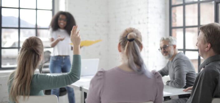 Woman raising her hand to ask a question.