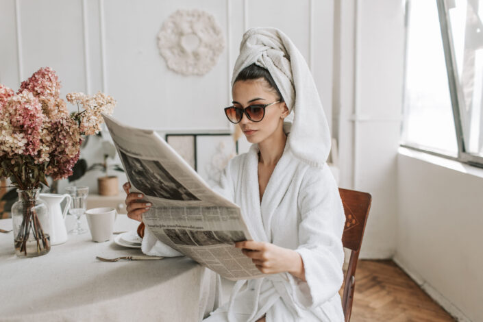 Woman sitting while reading a newspaper