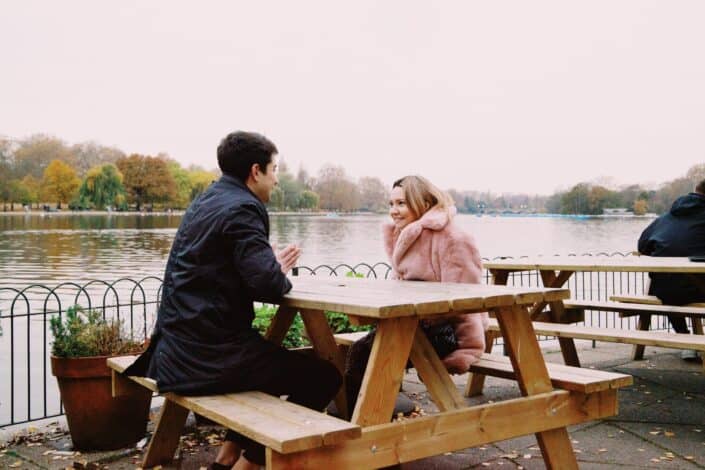 Cheerful young couple resting in Cafe at lakeside.