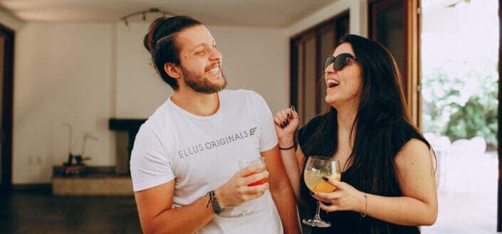 A couple sharing a laugh while drinking.