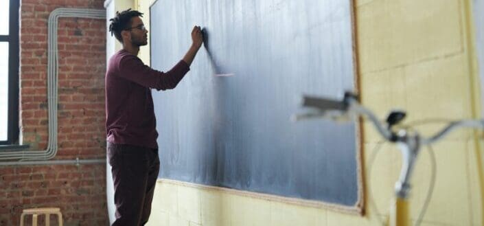 man writing on a board