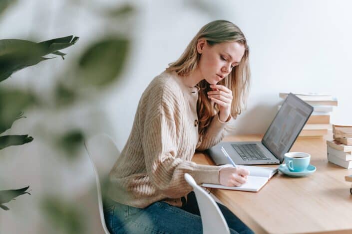 Woman taking notes while working