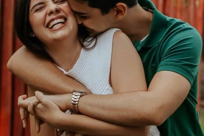 A man giving a playful back hug to his girlfriend.