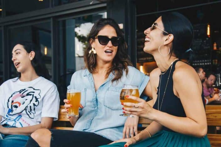 Casually dressed woman enjoiying a glass of beer talking to each other