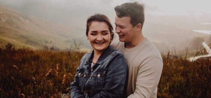 happy couple smiling in the field