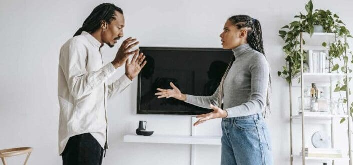 Annoyed young couple quarreling in cozy apartment