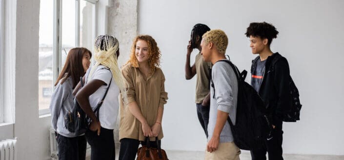 Diverse classmates talking to each other after studies