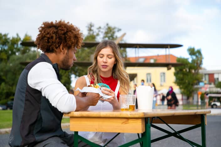 Couple eating donuts outside