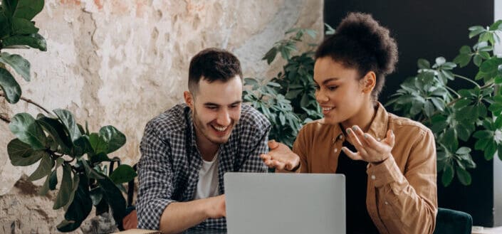 Man and Woman Talking while using Laptop