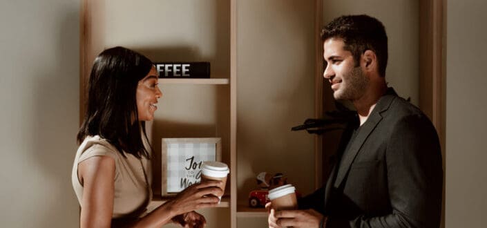 Man in Black Dress Shirt Talking to Woman in White