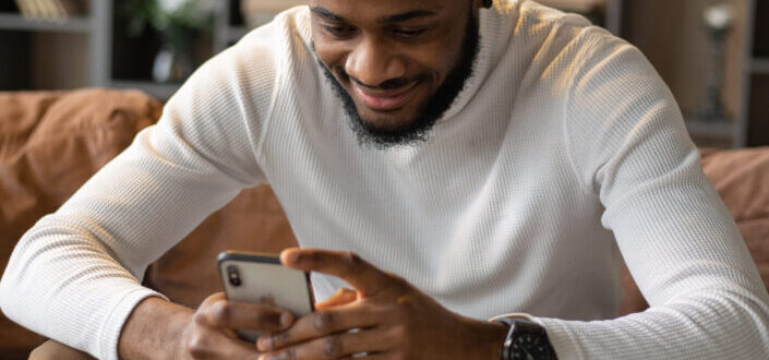 Man using smartphone while sitting on sofa