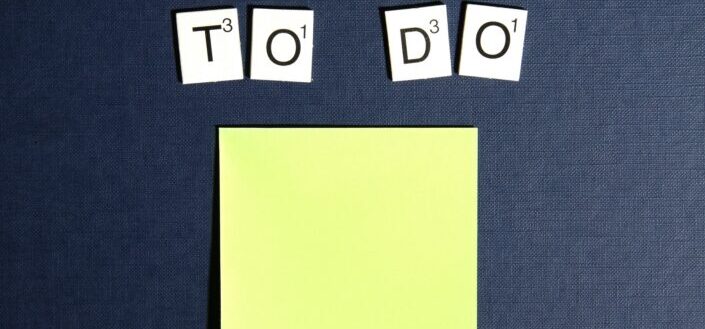 Note Card and Four Scrabble Tiles on Gray Surface