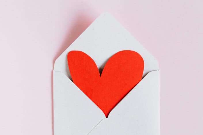 White envelope with red paper heart