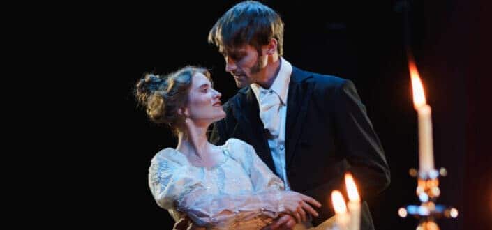 Elegantly dressed couple dancing romantically on their candlelit dinner