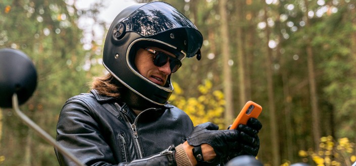 motorcycle rider holding a phone