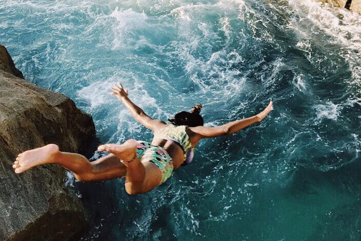 Woman diving from a cliff