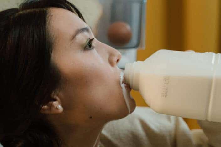 Woman drinking milk with spillage