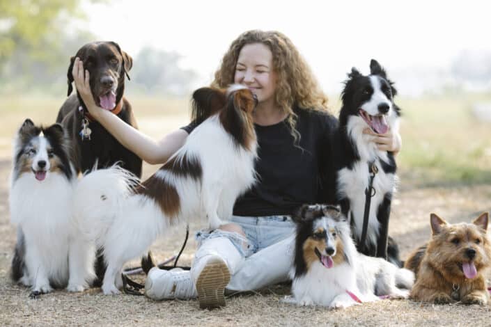 Woman surrounded by six dogs